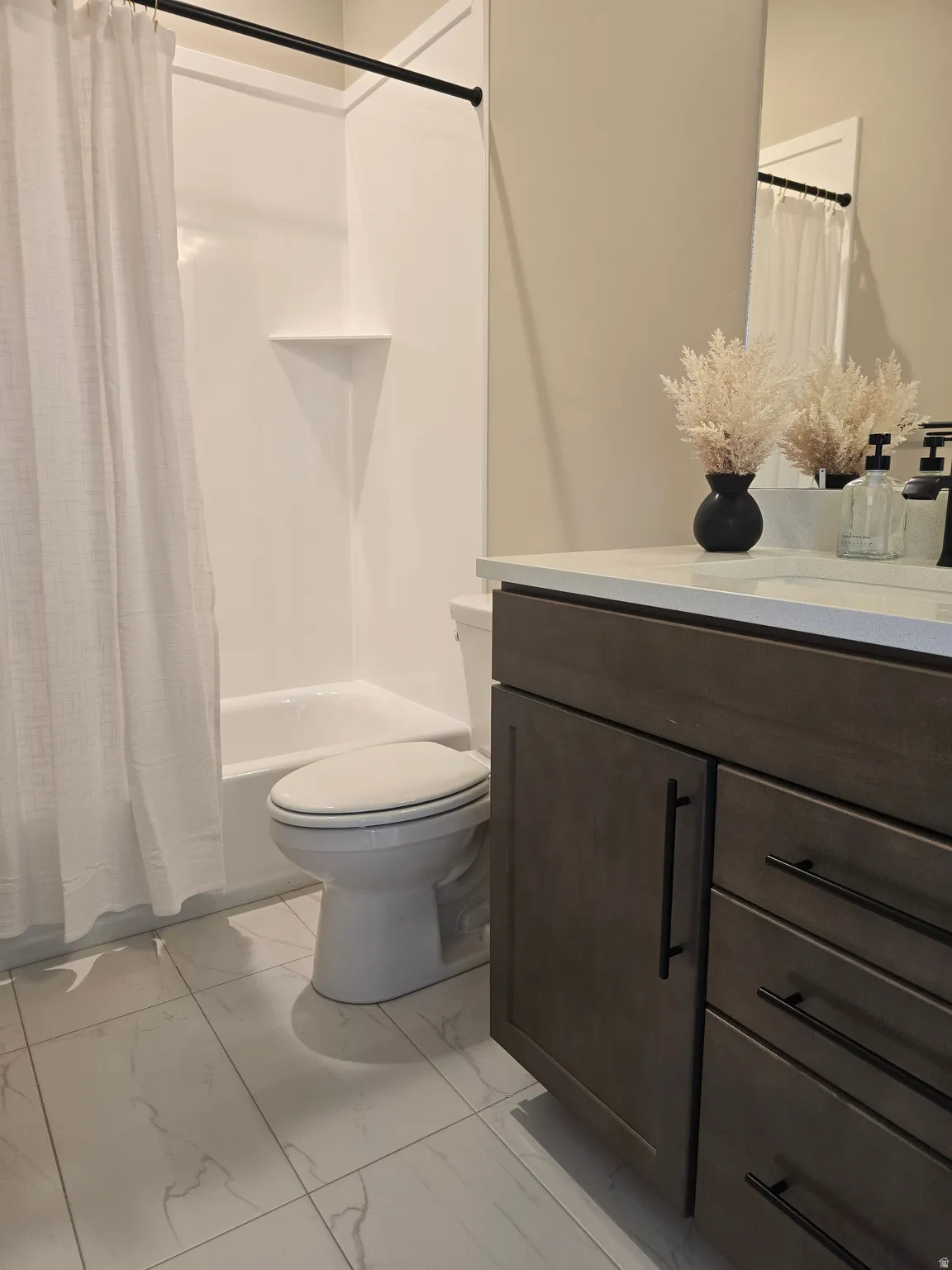 Bathroom with vanity, shower / bath combo, and light marble finish floors