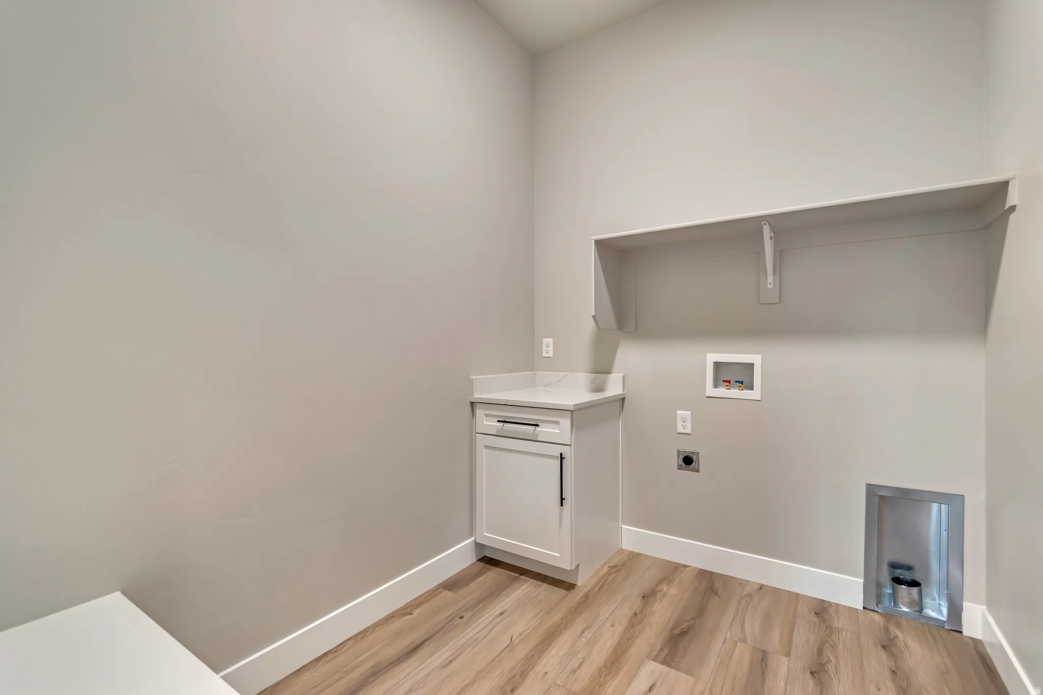 Laundry area featuring washer hookup, hookup for an electric dryer, and light wood-style floors