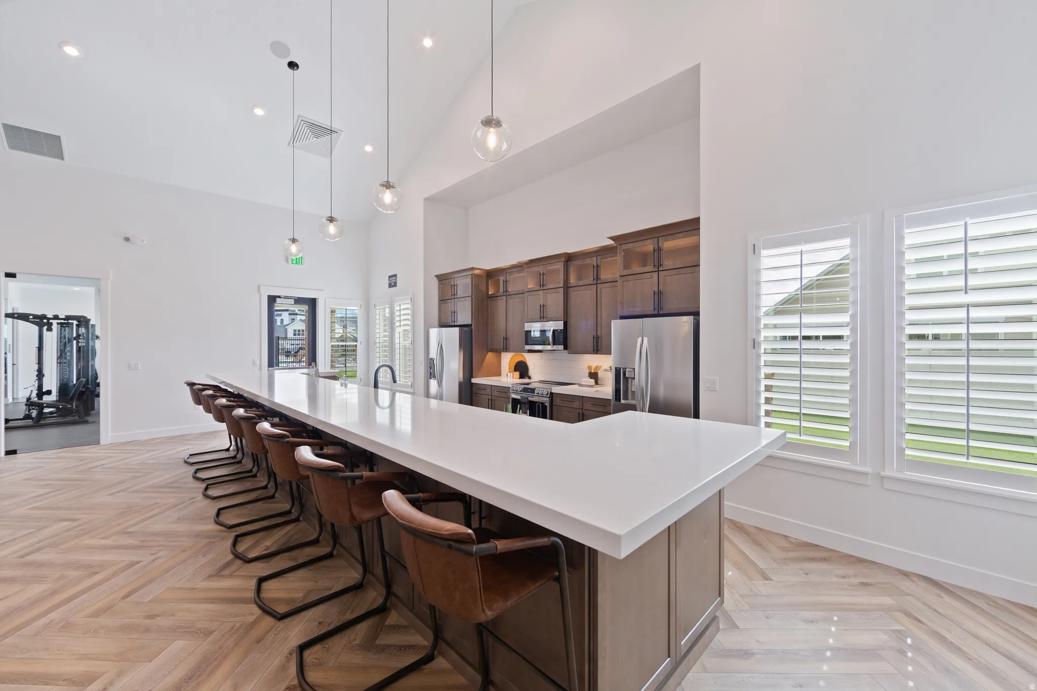 Kitchen featuring a breakfast bar area, a large island, pendant lighting, dark wood finish cabinetry, and stainless steel appliances