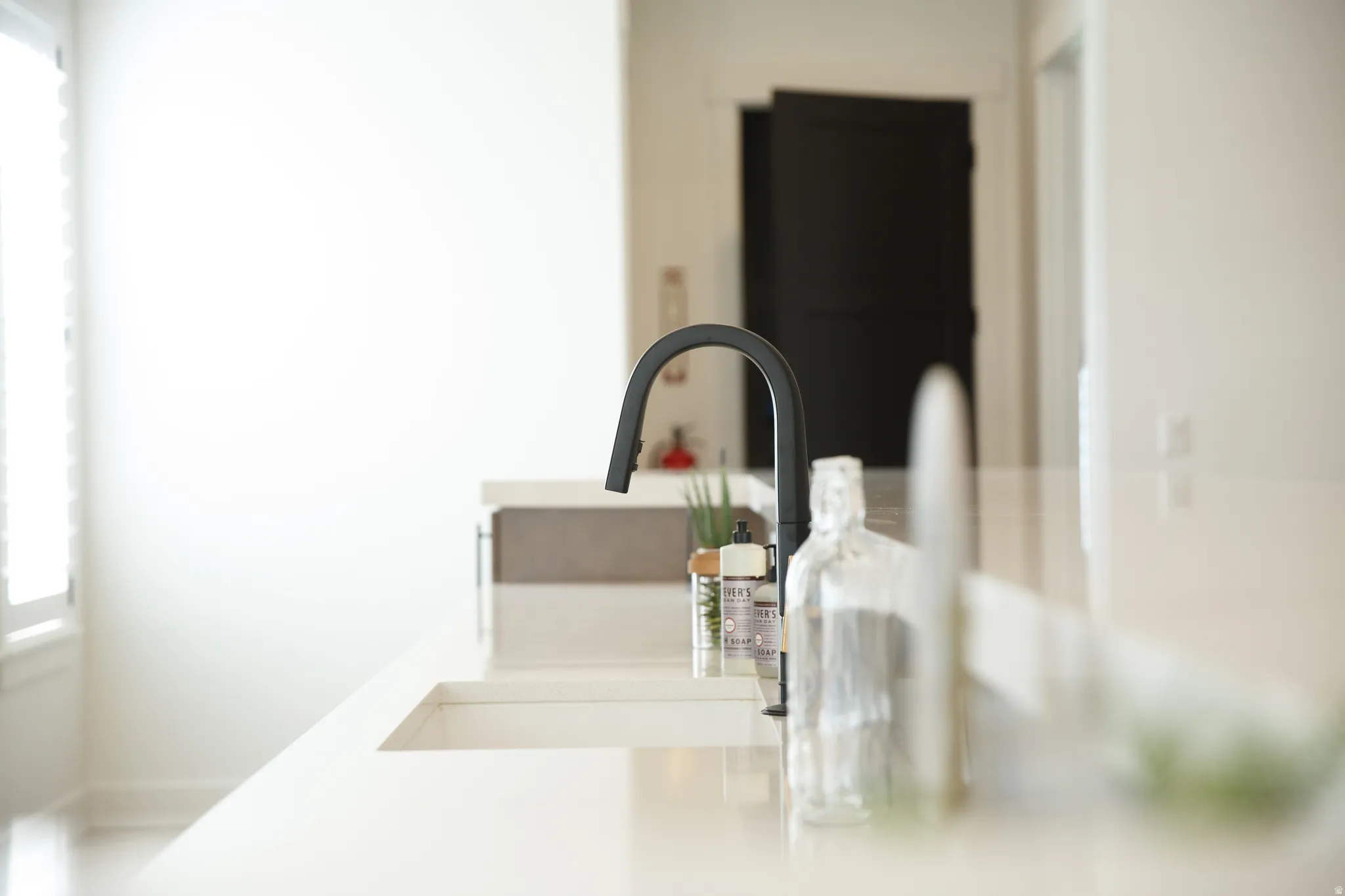Kitchen view of a sink and light countertops