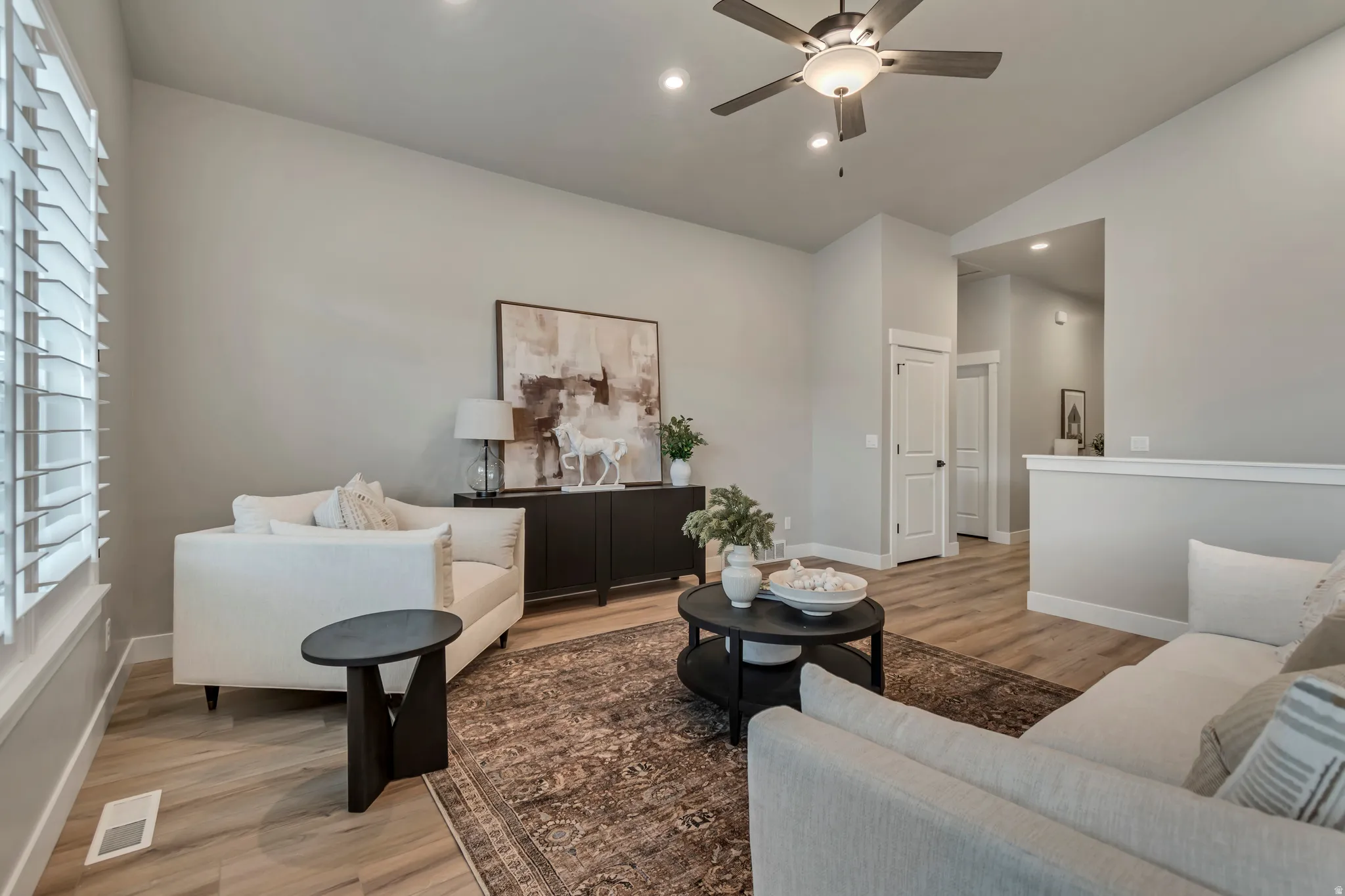 Living room featuring light wood-style floors, a ceiling fan, lofted ceiling, and recessed lighting