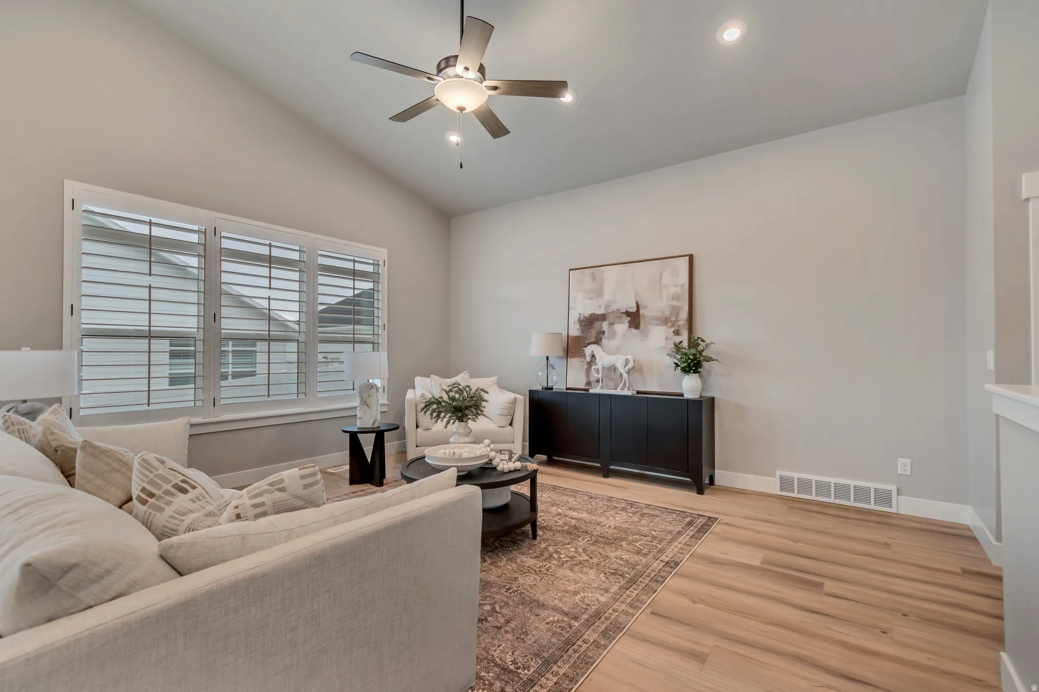 Living room with a ceiling fan, light wood-type flooring, vaulted ceiling, and recessed lighting