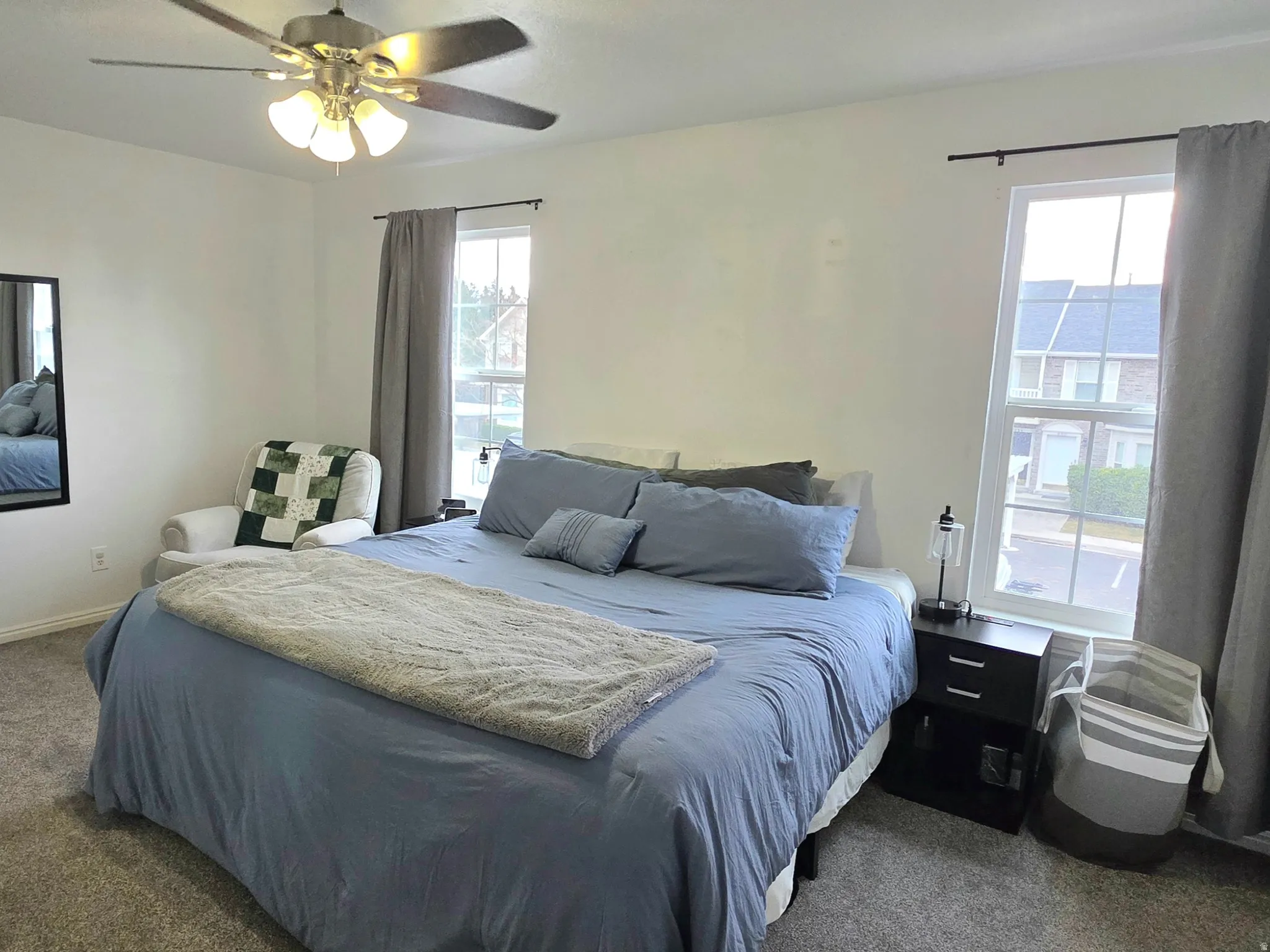 Main bedroom featuring multiple windows and ceiling fan