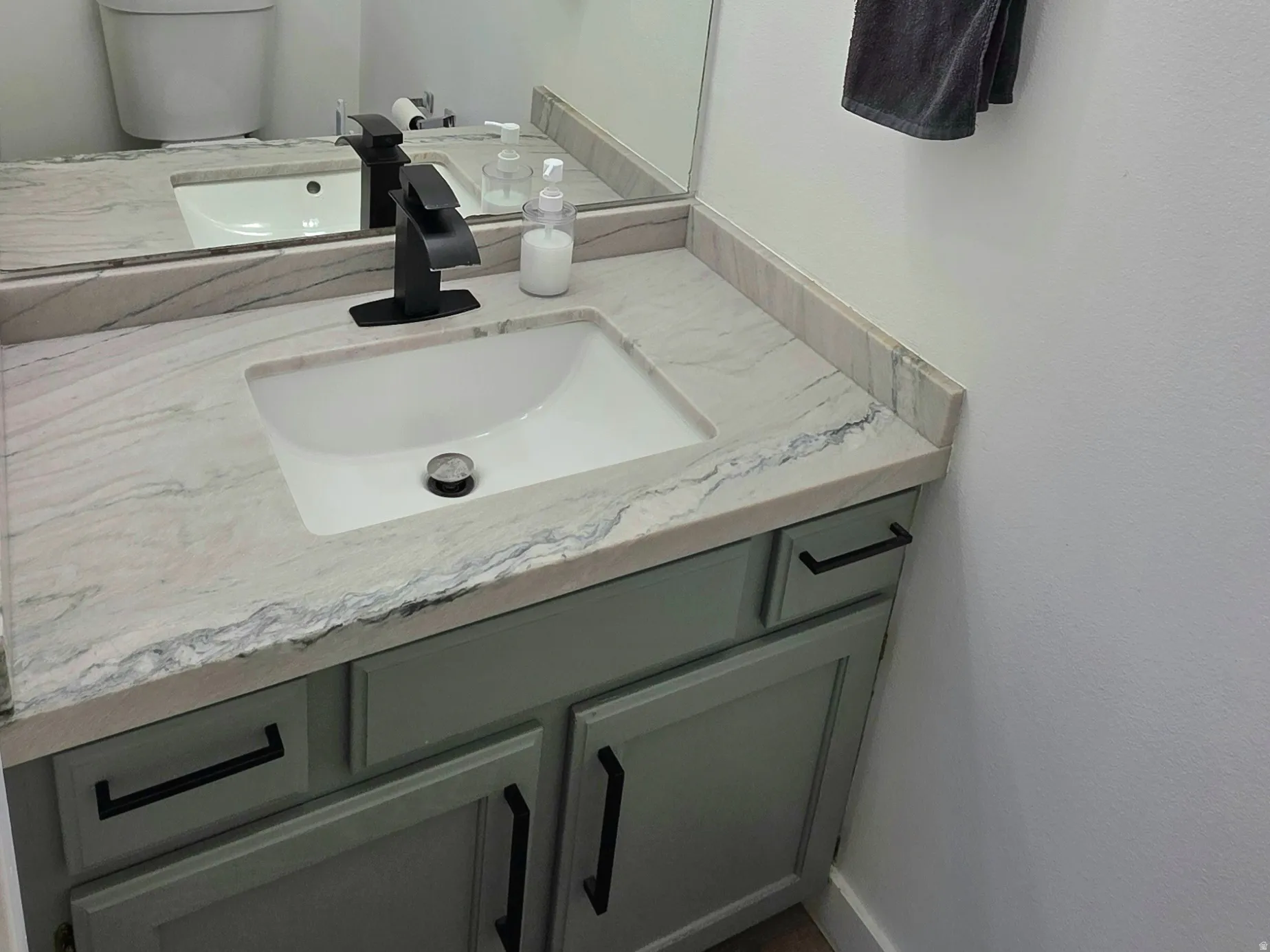 Half bath featuring vanity and dark wood-type flooring