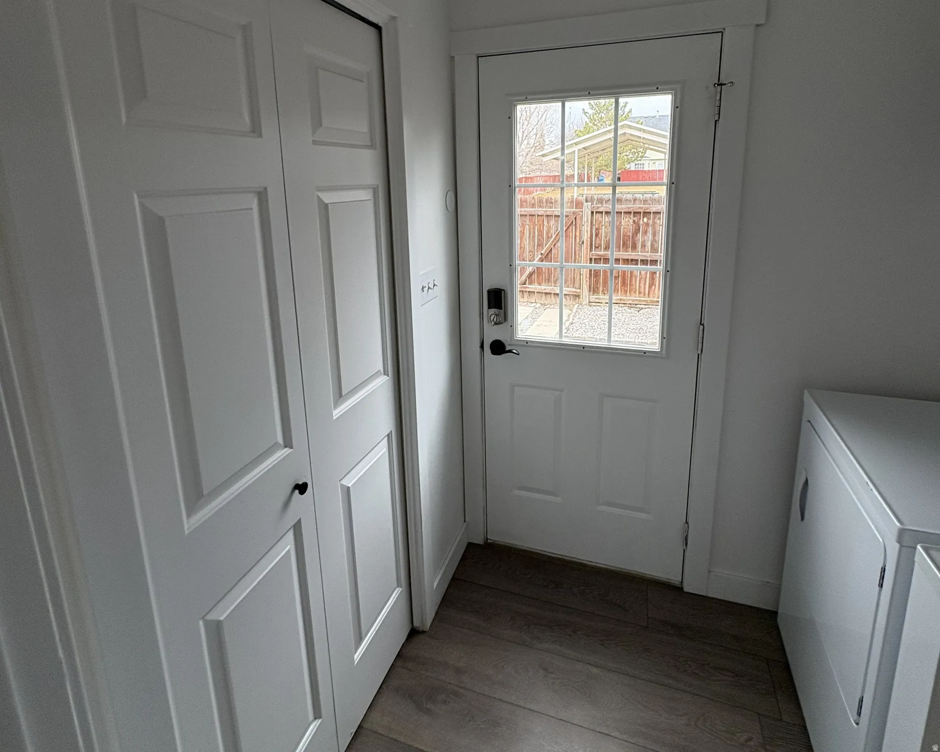 Entryway with wood finished floors and washing machine and dryer