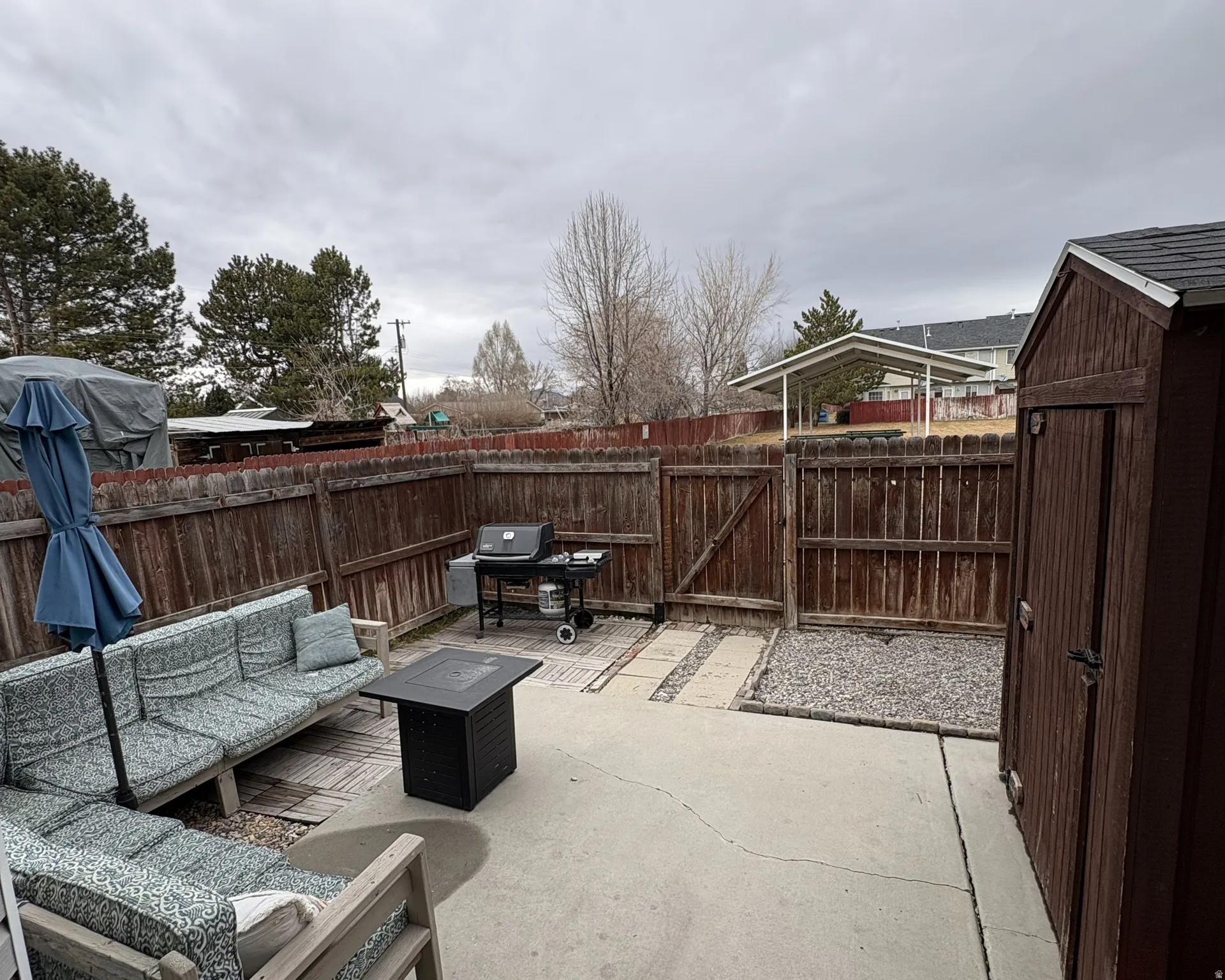 Fenced backyard featuring an outdoor living space with a storage unit
