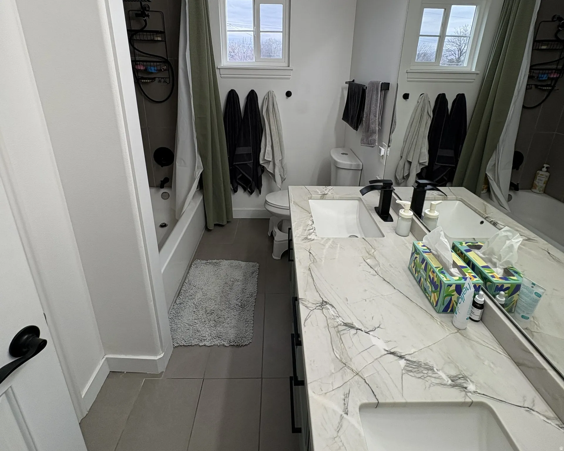 Full bath featuring shower / bath combo, vanity, and dark tile patterned floors