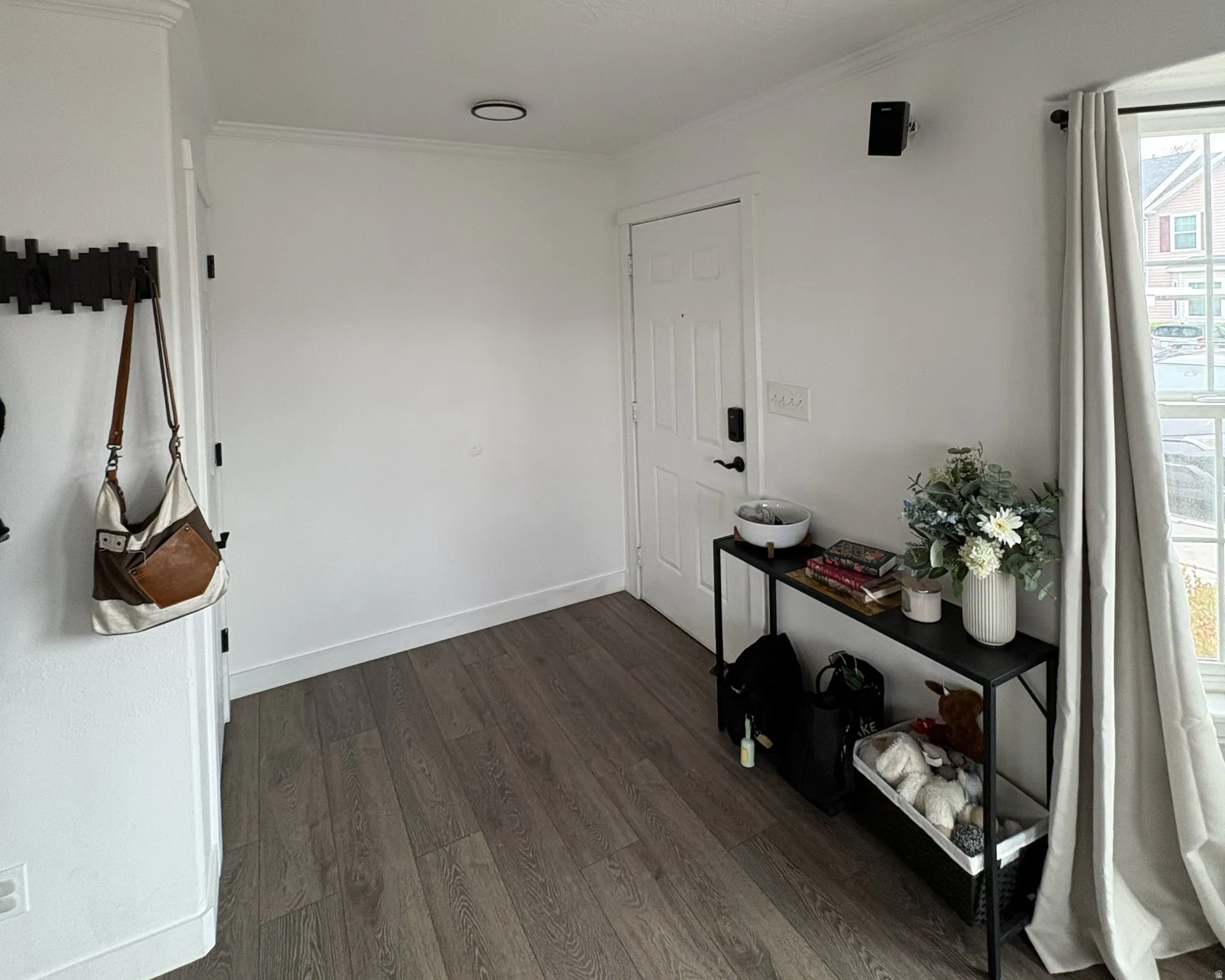 Foyer entrance with dark wood finished floors and crown molding