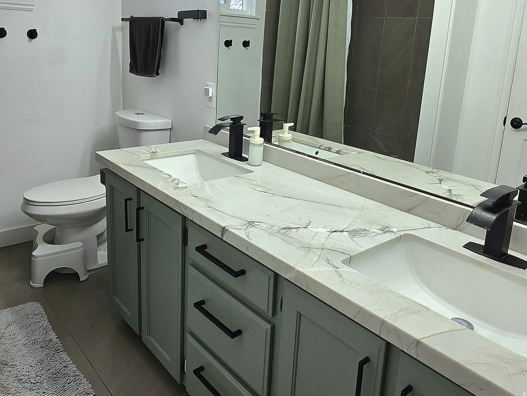 Full bathroom featuring double vanity & plenty of natural light