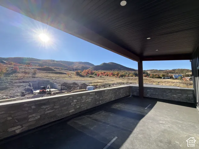 Covered outdoor space featuring a stone-clad wall and recessed lighting
