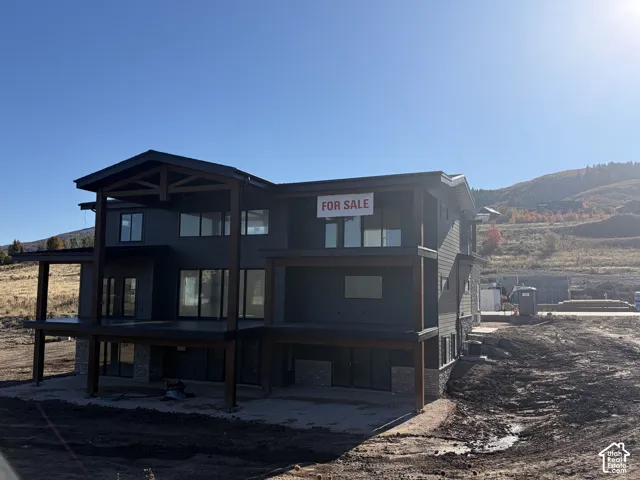 Two-story contemporary residence with dark gray siding and stone accents