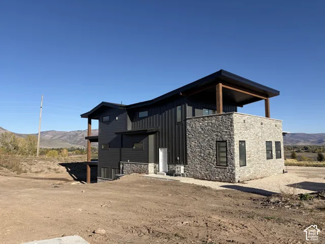 Contemporary architectural design featuring dark vertical siding and natural stone accents