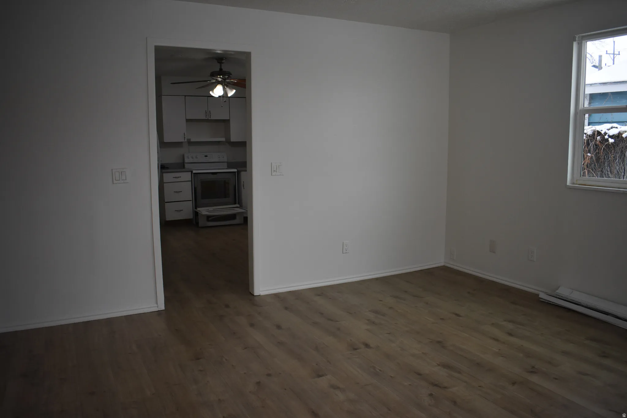 Empty room featuring dark wood-type flooring and ceiling fan