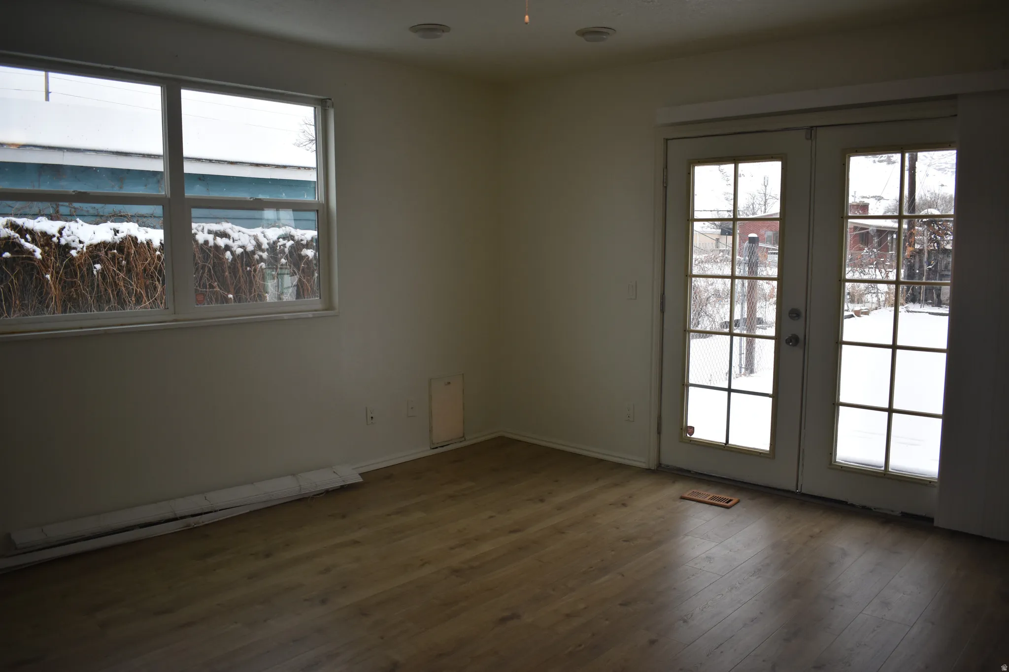 Spare room featuring french doors, healthy amount of natural light, and wood finished floors