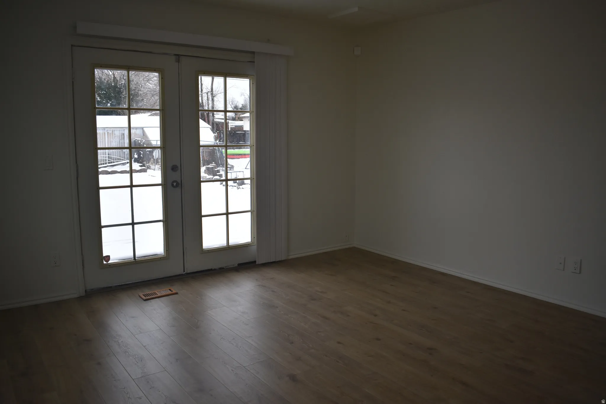 Unfurnished room featuring french doors and dark wood-style floors