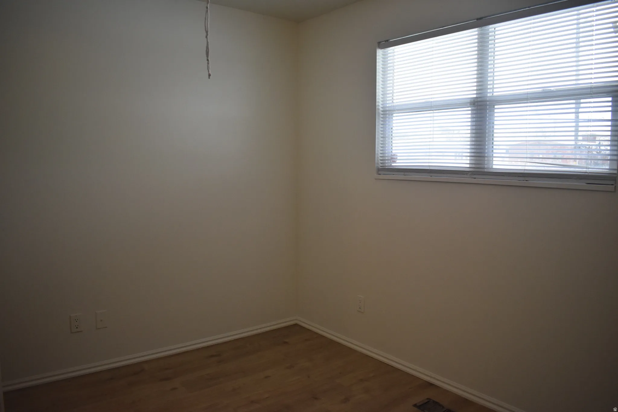 Empty room featuring dark wood-type flooring and baseboards