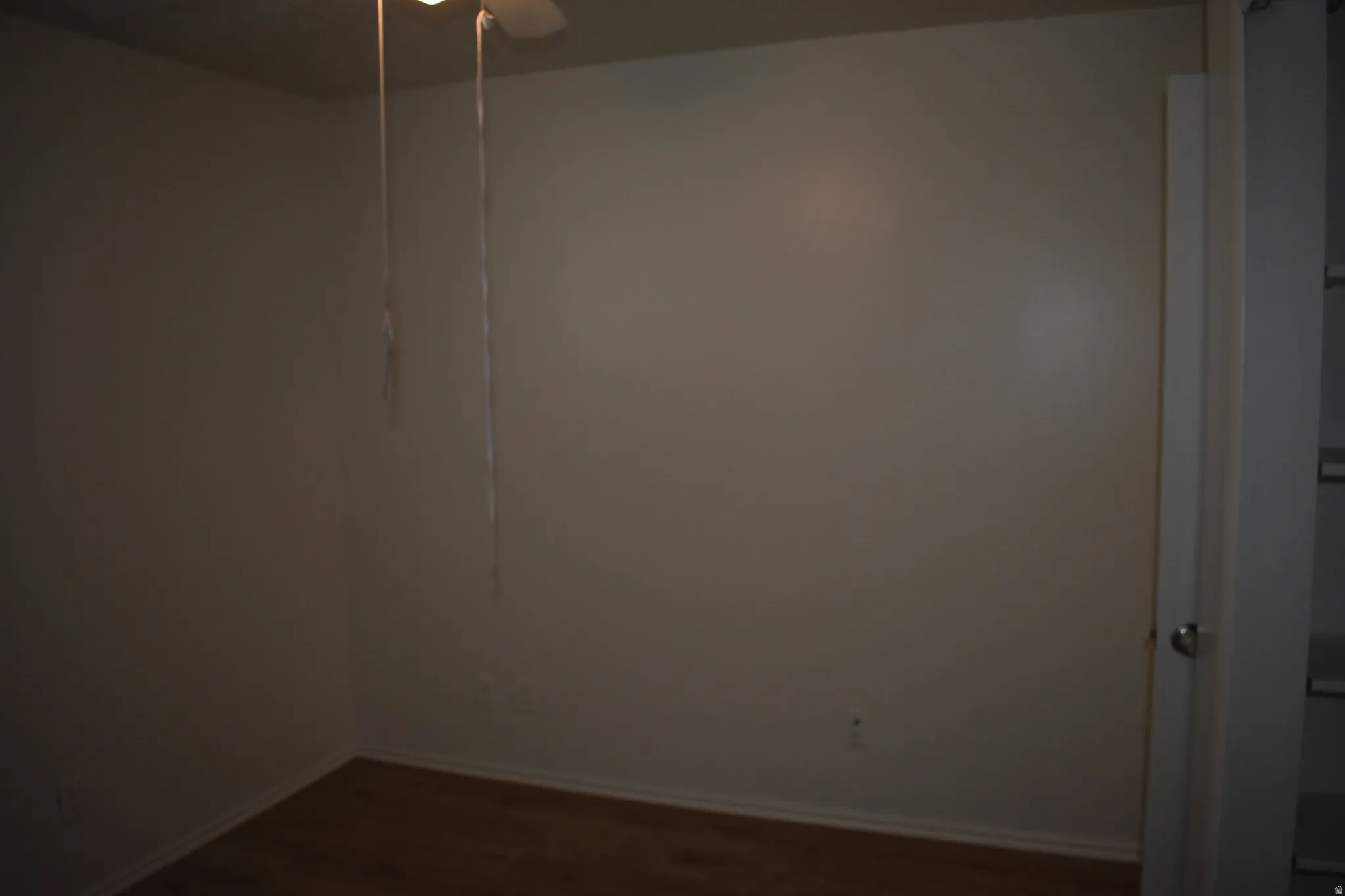 Unfurnished room with dark wood-type flooring and a ceiling fan