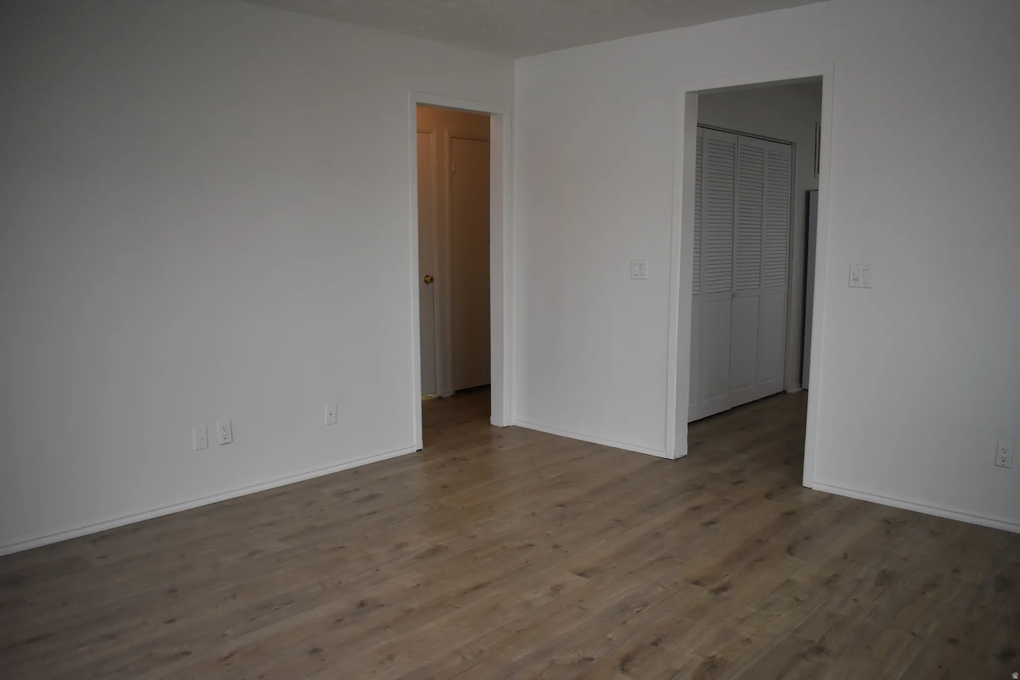 Unfurnished bedroom with wood finished floors and baseboards