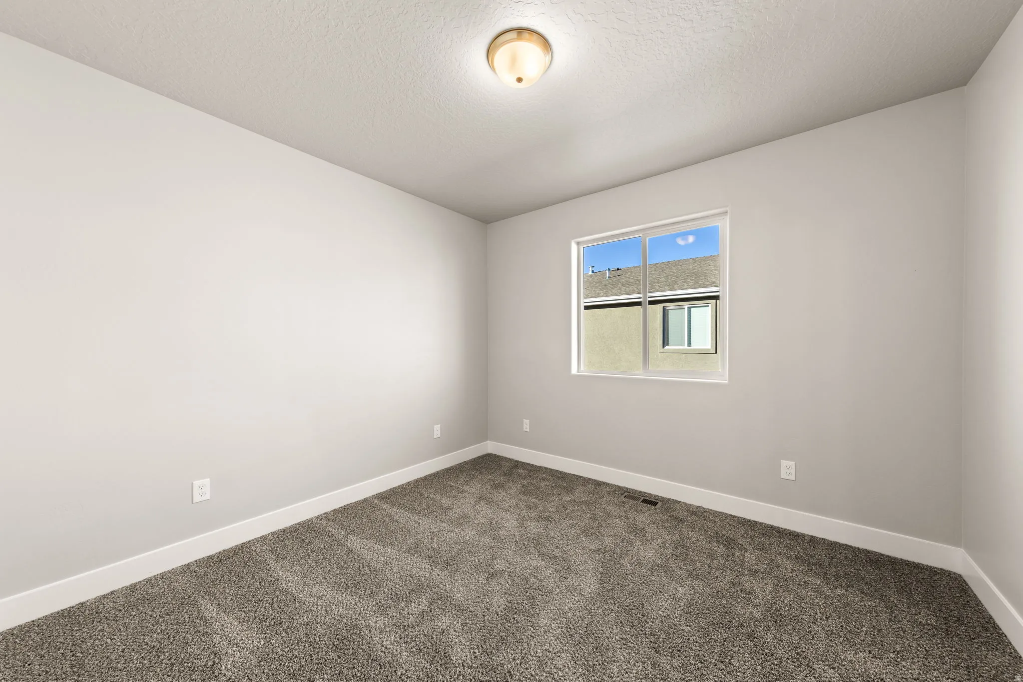 Unfurnished room featuring carpet floors and a textured ceiling