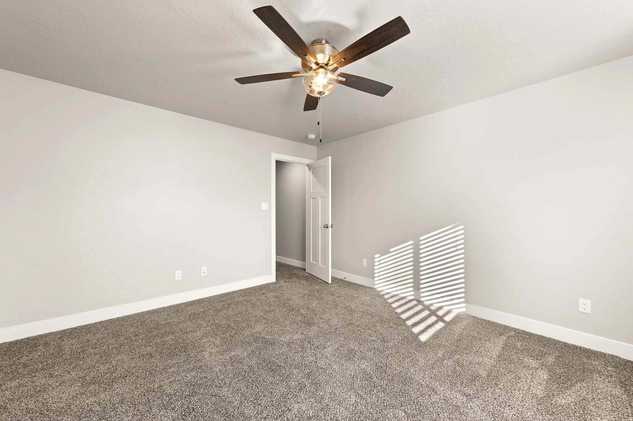 Carpeted empty room with baseboards and ceiling fan