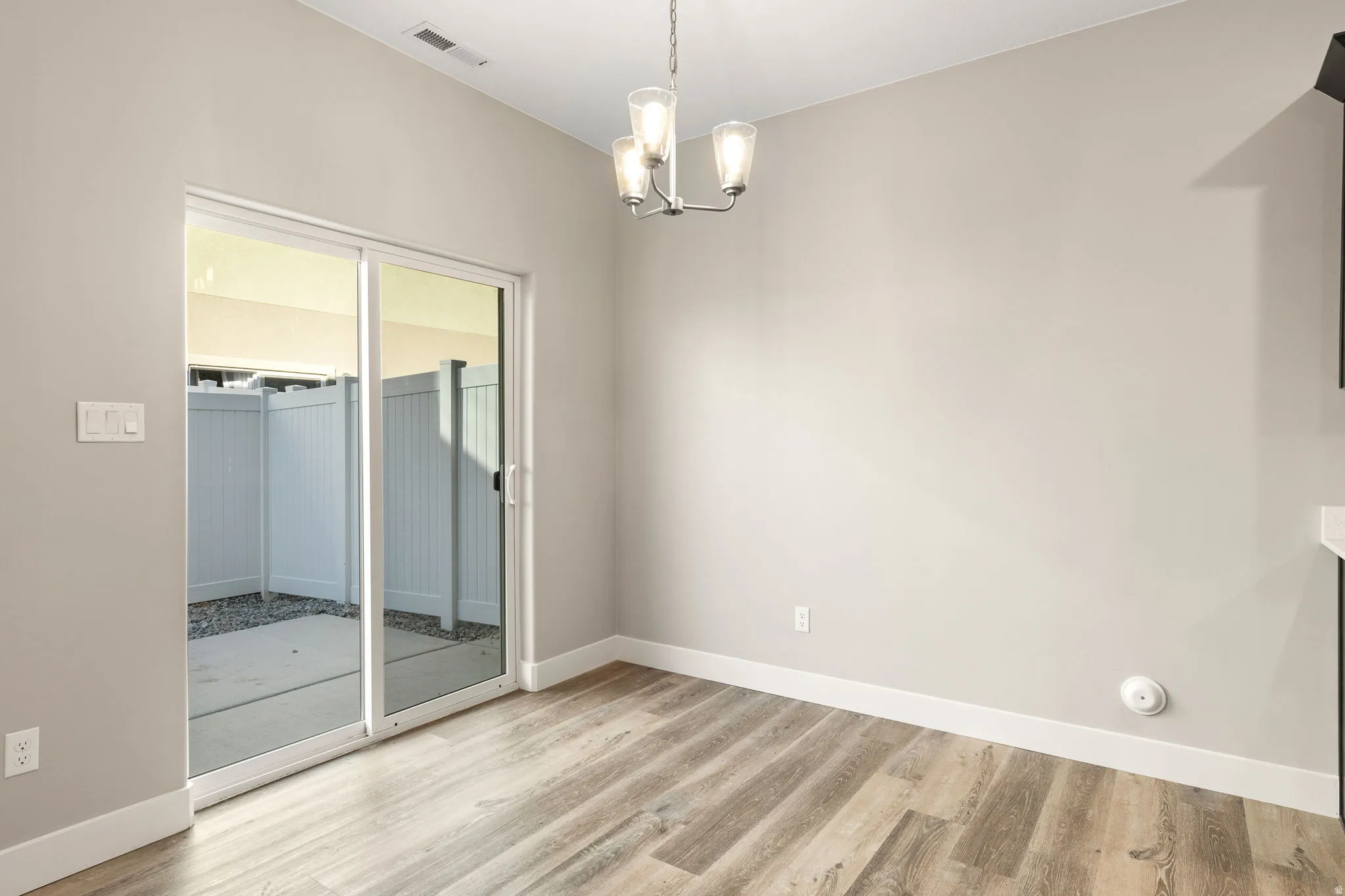 Unfurnished dining area featuring suspended lighting and light wood-style floors