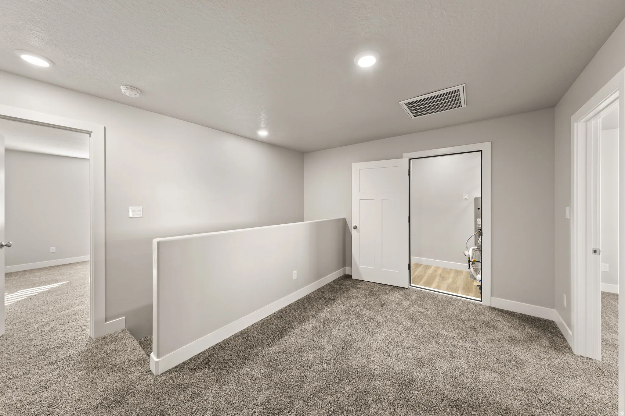 Below grade area featuring carpet, recessed lighting, and a textured ceiling