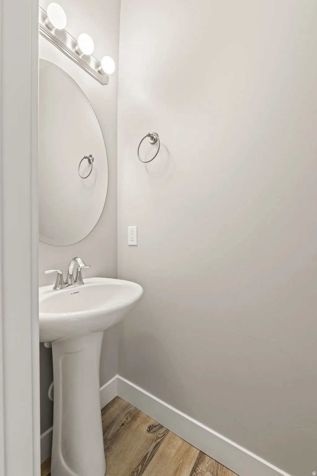 Bathroom with baseboards and light wood-type flooring