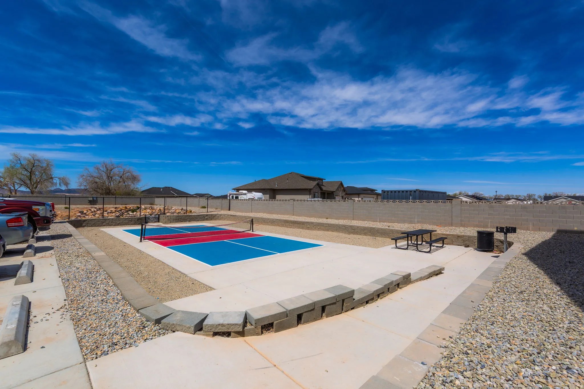 View of pool featuring patio surround and a tennis court