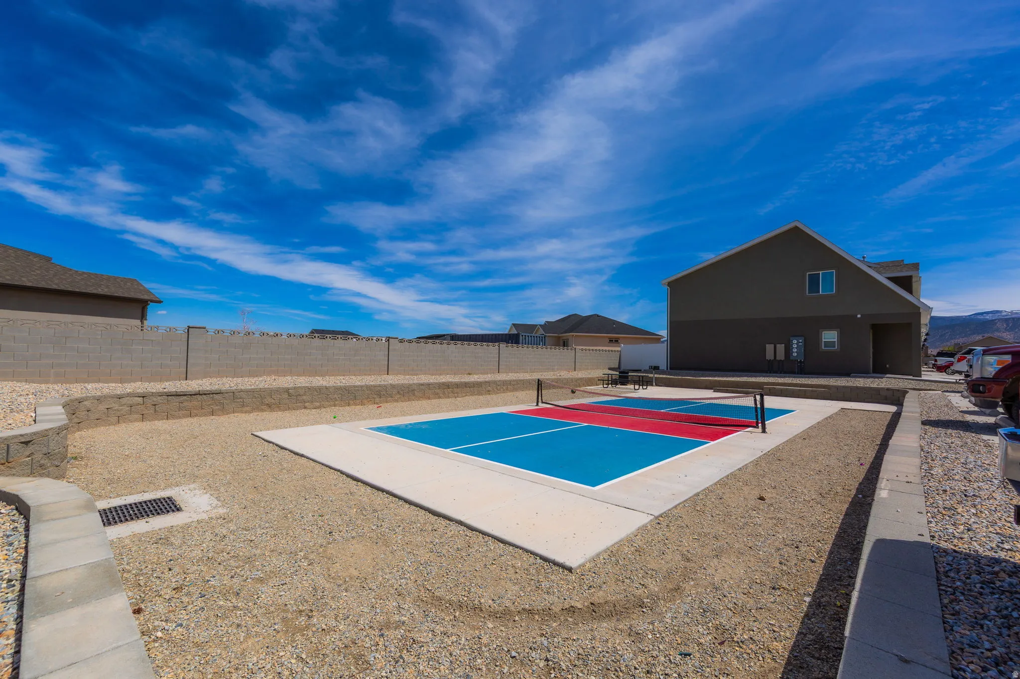 View of property's community with a tennis court and a fenced backyard