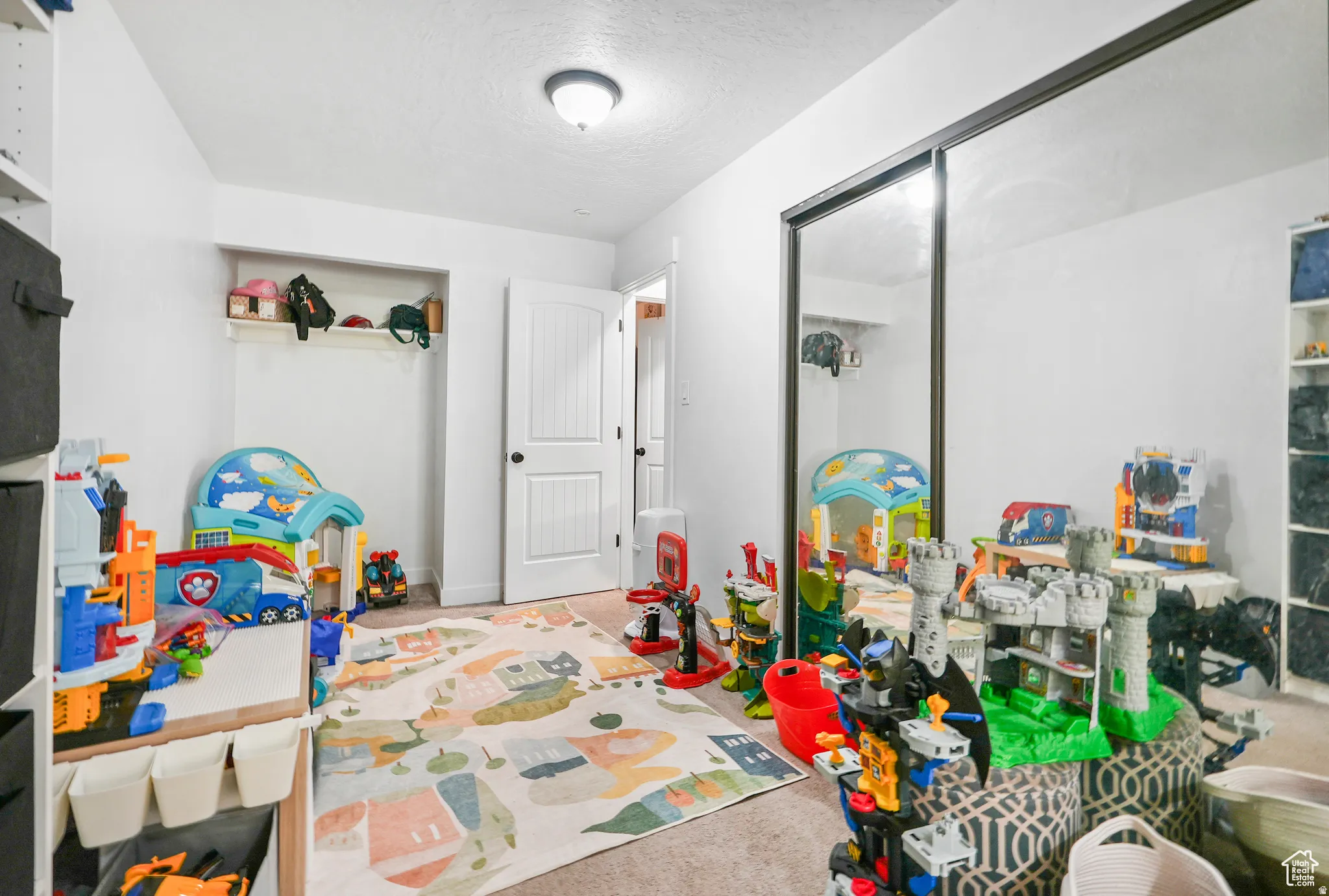 Playroom with carpet flooring and a textured ceiling