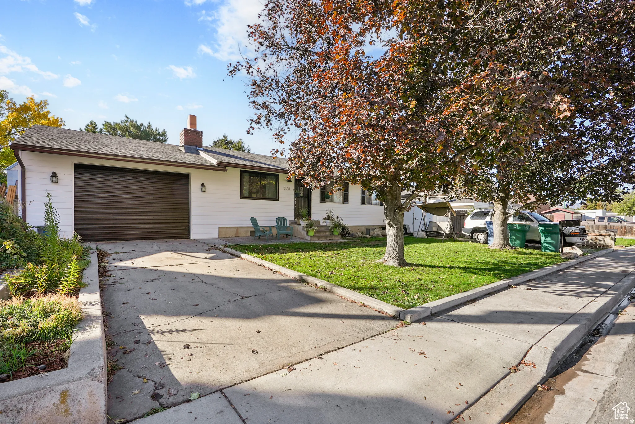 Single story home with a chimney, a front lawn, driveway, an attached garage, and roof with shingles