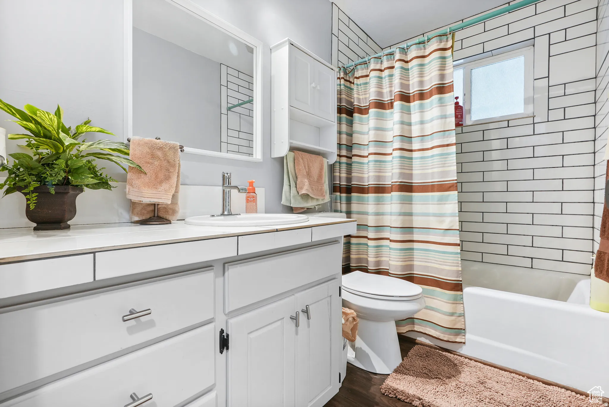 Bathroom with shower / tub combo with curtain, vanity, and dark wood finished floors