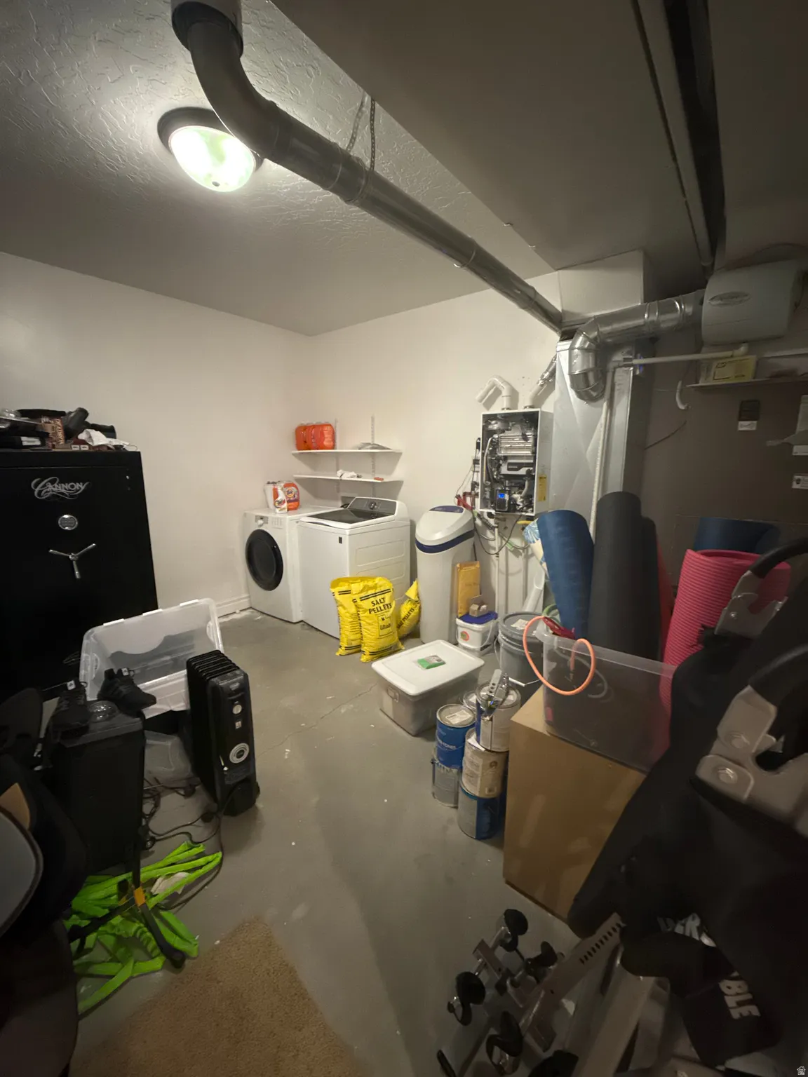 Finished basement with a water softener, separate washer and dryer, and a textured ceiling