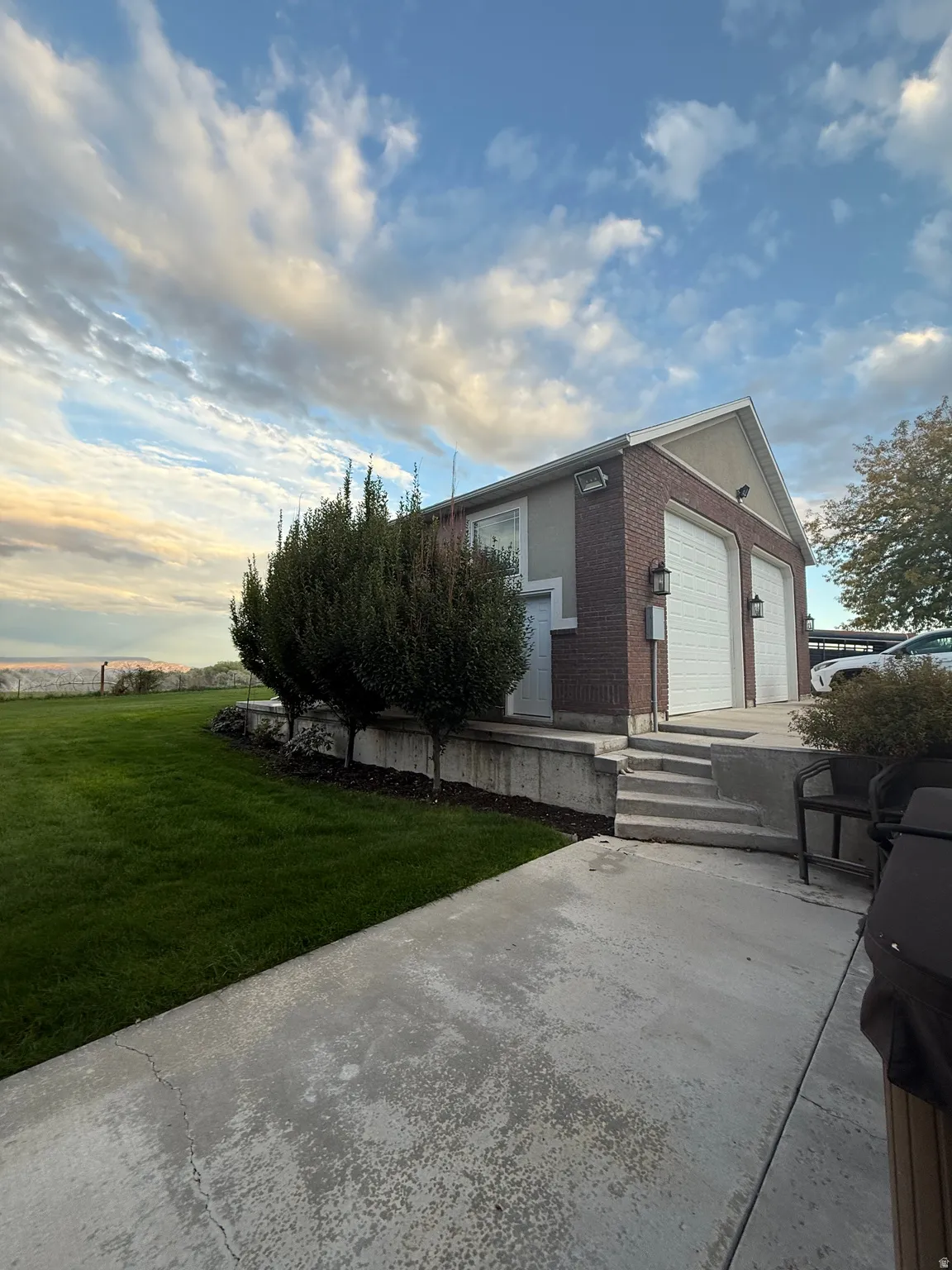 View of side of home with a lawn, brick siding, and an attached garage
