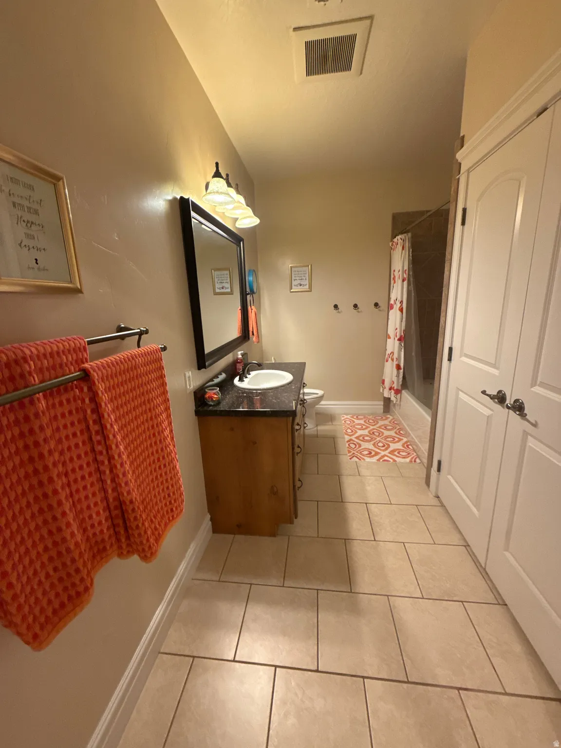 Bathroom with vanity, light tile patterned floors, and shower / tub combo