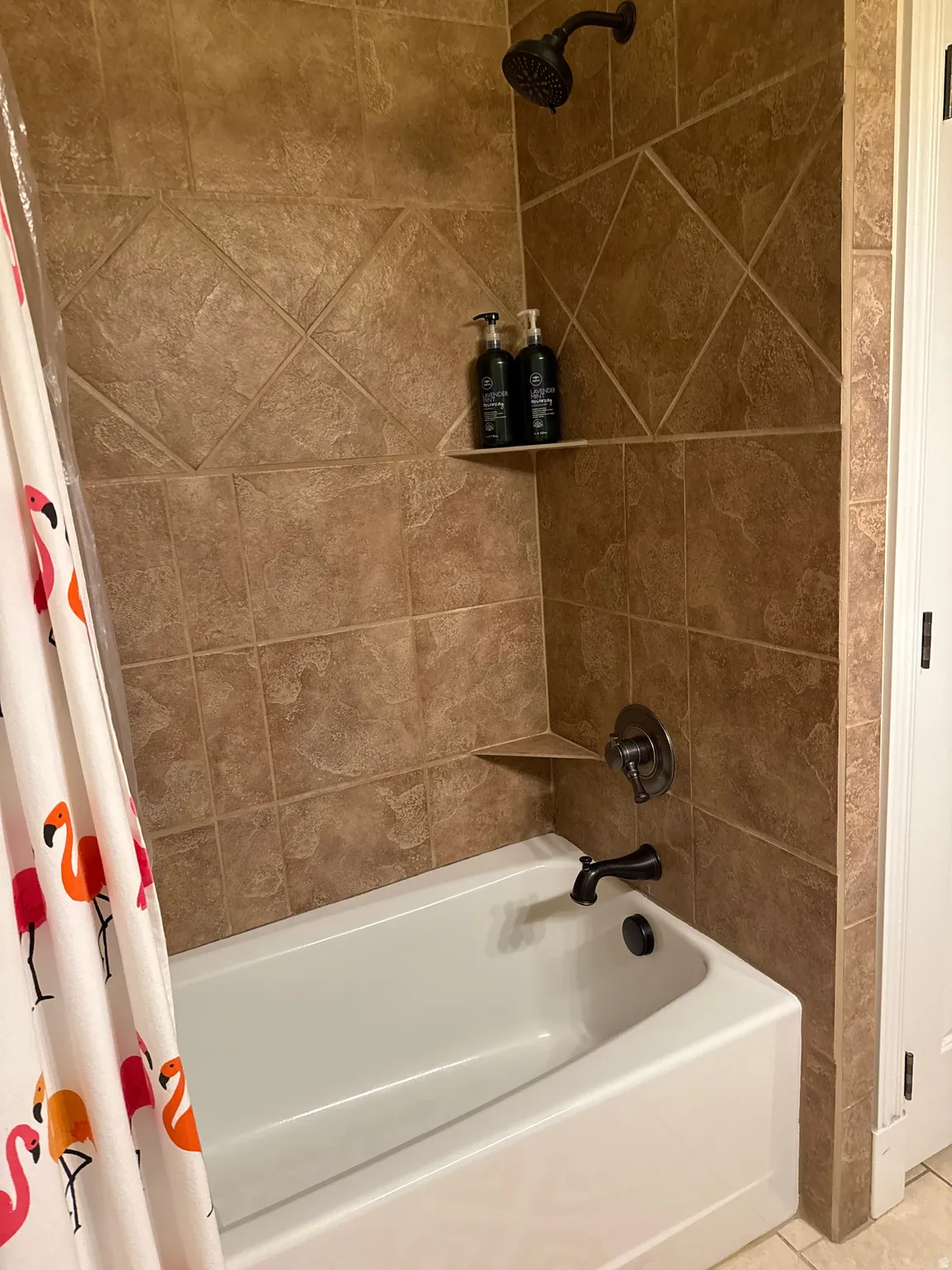 Bathroom featuring shower / tub combo with curtain and tile patterned flooring