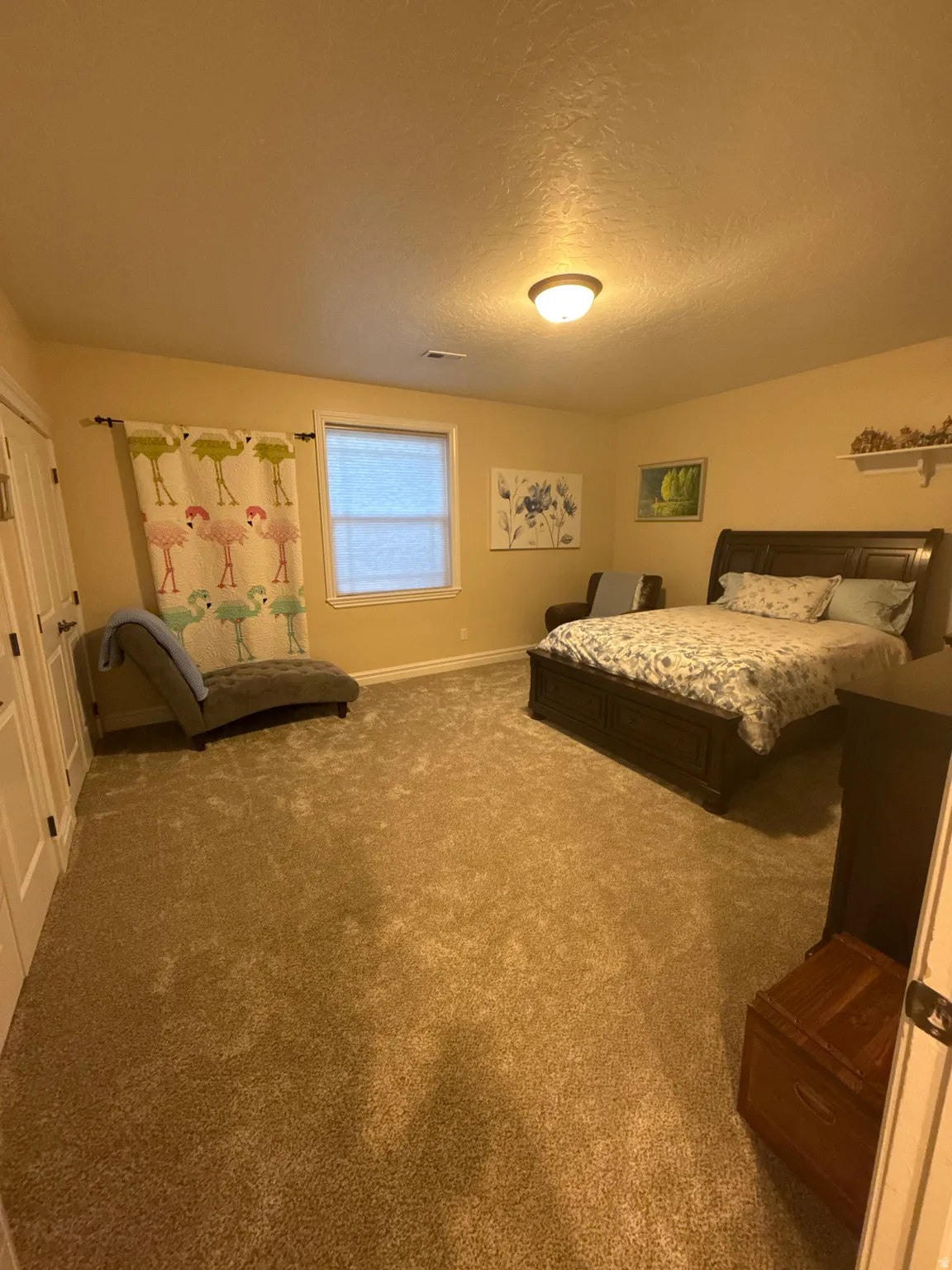 Carpeted bedroom featuring baseboards and a textured ceiling