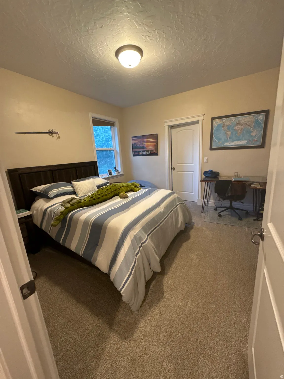 Bedroom featuring carpet and a textured ceiling