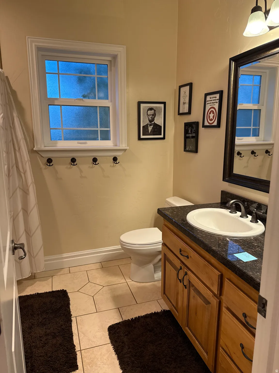 Bathroom featuring vanity, light tile patterned flooring, and curtained shower