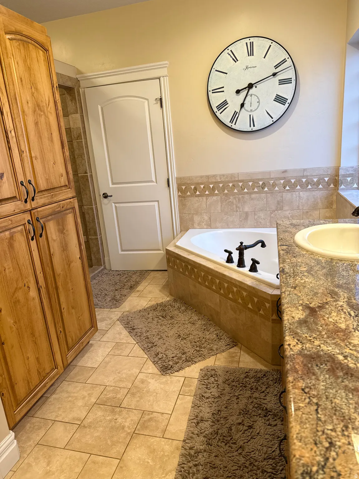 Bathroom featuring vanity, a garden tub, and light tile patterned floors