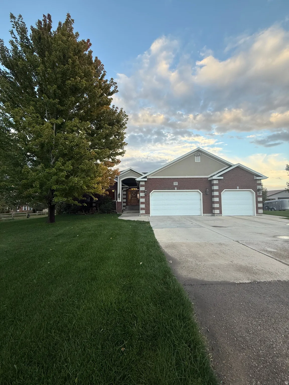 Ranch-style house with driveway, a front lawn, and an attached garage