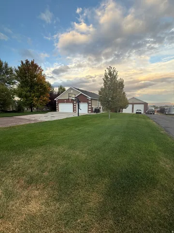 Single story home with a front yard and a detached garage