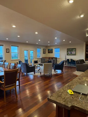 Living area with a textured ceiling, dark wood-type flooring, recessed lighting, and french doors