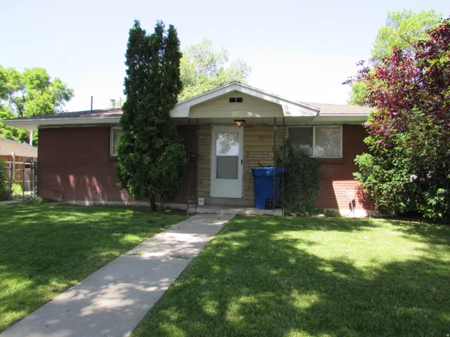 View of front of house with a front yard and brick siding