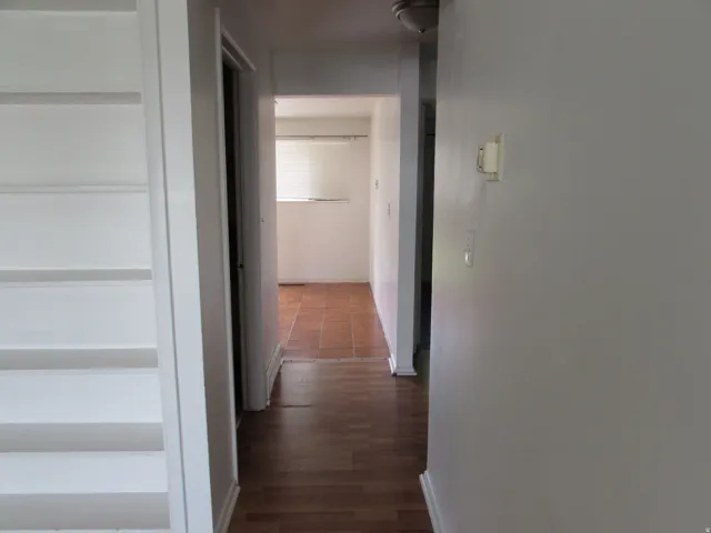 Corridor featuring baseboards and dark wood-style flooring