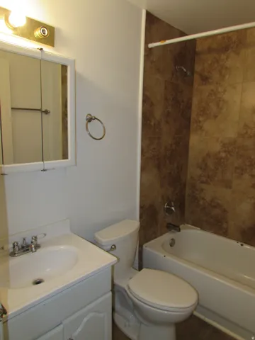Bathroom featuring vanity, washtub / shower combination, and tile patterned flooring