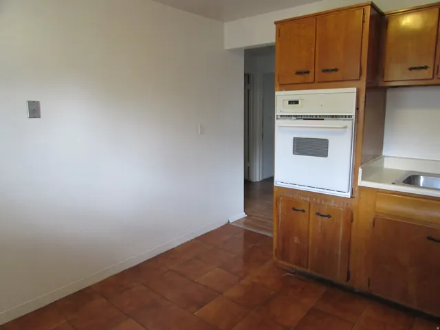Kitchen featuring light countertops, oven, and wood finish cabinetry