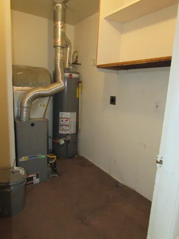 Utility room featuring gas water heater and heating unit