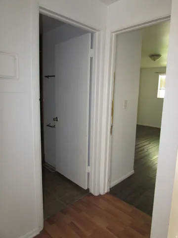 Hall with dark wood finished floors and baseboards