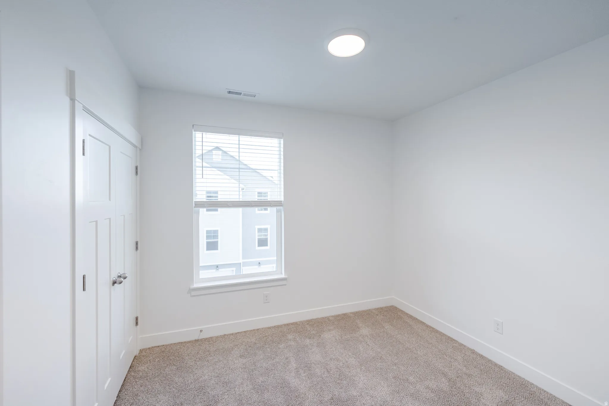Bright room with neutral wall finishes and a window featuring white blinds